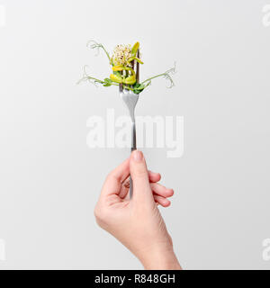 Donna mano azienda micro verdi sulla forcella. Mangiare sano, fresco giardino produrre coltivati biologicamente. Simbolo di salute e vitamine dalla natura. Microgreen Foto Stock