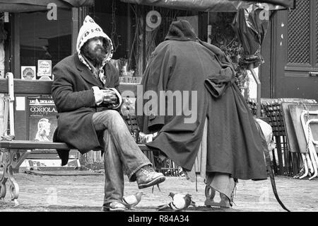 Carattere eccentrico con tutti i suoi averi, si siede su una panca in Place du Marché Ste-Catherine, le Marais, Paris, Francia, versione in bianco e nero Foto Stock