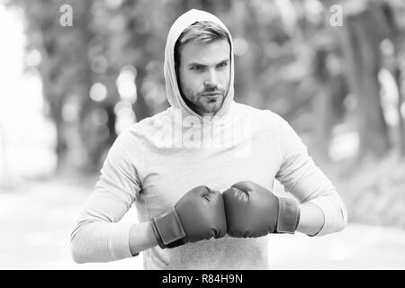 Io sono pronto a combattere. L'uomo atleta sulla faccia di concentrato con guanti sport praticando la boxe punch, natura dello sfondo. Boxer testa cofano pronti a combattere. Boxer sportivo della formazione con i guantoni. Foto Stock