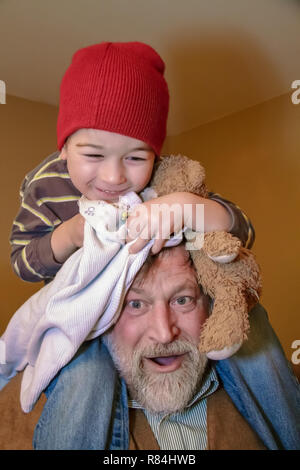 Tre anni di vecchio ragazzo seduto sul suo nonno del spalle. (MR) Foto Stock