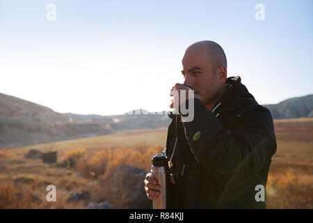 Camper bevendo un tè caldo e coffeo da thermos Foto Stock