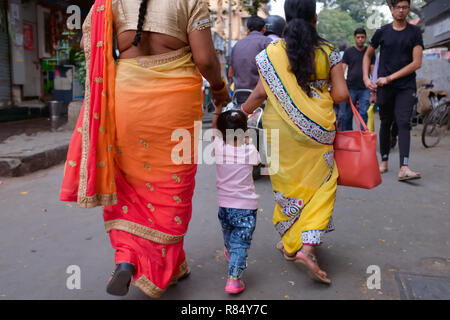 Una piccola ragazza indiana amorevolmente preso per mano da due parenti di sesso femminile, in una passeggiata in South-Indian enclave di Matunga Oriente, Mumbai, India Foto Stock