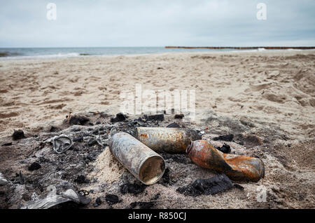 Bruciò lattine su una spiaggia, inquinamento ambientale concetto. Foto Stock