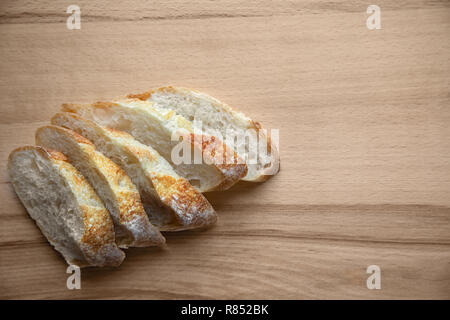 Pane appena sfornato a fette di pane su un tavolo di legno. Foto Stock