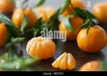 Tangerini freschi con foglie su un tavolo. Legno scuro sfondo, alta risoluzione Foto Stock