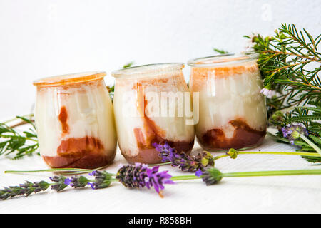Tre bianco yogurt naturale con la marmellata di arance sul fondo del vaso di vetro Foto Stock