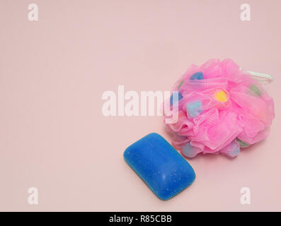 Womans fancy spugna bagno con mare blu sale sapone su sfondo rosa Foto Stock