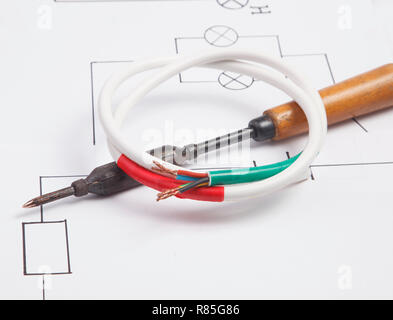 Un ferro da saldatore su uno sfondo di lo schema elettrico Foto Stock
