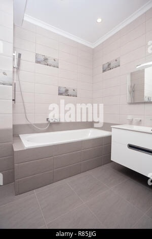 Epmty interni minimalisti sfondo, bagno di moderno appartamento, specchio, vasca da bagno e lavandino in colori chiari, nessuno, con spazio copia, verticale Foto Stock