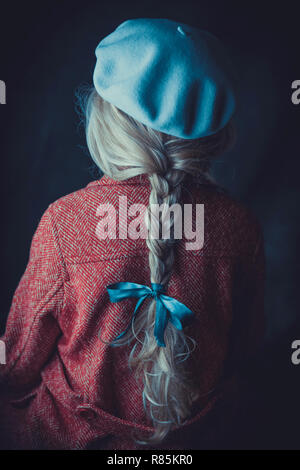 Donna storico in cappotto invernale in possesso di un libro Foto Stock