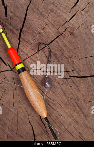 Strumenti da pesca gancio e bobber su uno sfondo di legno Foto Stock