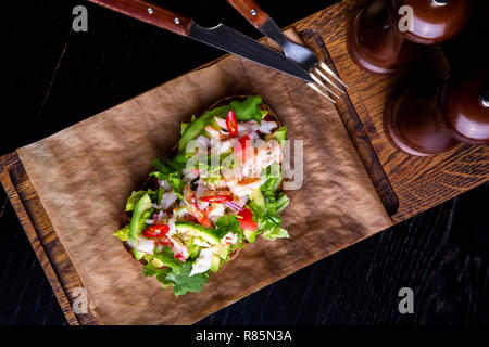 Deliziose bruschette con polpa di granchio nel ristorante dello sfondo. Esclusiva sano cibo servito su una tavola di legno e carta craft Foto Stock