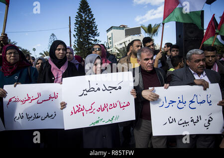 La città di Gaza, la striscia di Gaza, la Palestina. Xiii Dec, 2018. I dimostranti sono visti tenendo cartelli e bandiere durante la protesta.i sostenitori delle fazioni palestinesi hanno partecipato a una manifestazione di protesta, seguendo l'esecuzione da parte dell'esercito israeliano dei tre palestinesi della Cisgiordania. Credito: Mahmoud Issa/SOPA Immagini/ZUMA filo/Alamy Live News Foto Stock