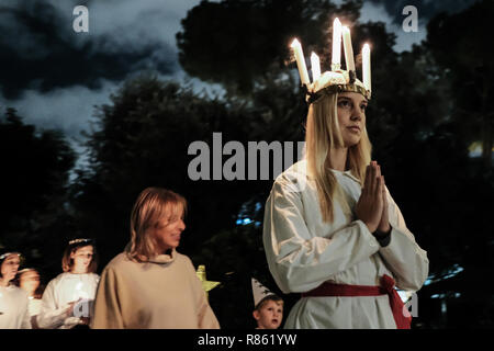 Gerusalemme, Israele. 13 dicembre, 2018. La svedese Istituto Teologico (STI) in Gerusalemme ospita Santa Lucia i festeggiamenti per la giornata di commemorazione Lucia di Siracusa (283-304), Saint Lucia, Saint Lucia, o Sancta Lucia. La festa è diventata una festa di luce, particolarmente celebrata nei paesi scandinavi, dove le giovani ragazze tradizionalmente vestita di bianco con un rosso anta, portano le palme e le corone di usura delle candele sulle loro teste. Credito: Nir Alon/Alamy Live News Foto Stock