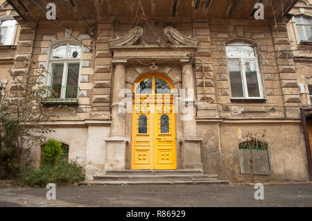 Il vecchio cortile affascinante con in Odessa, Ucraina. Ingresso in un vecchio edificio con colore giallo brillante porta. Foto Stock