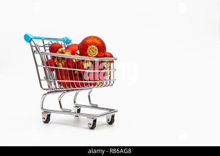 Carrello della spesa pieno di rosso le palle di Natale su sfondo bianco Foto Stock