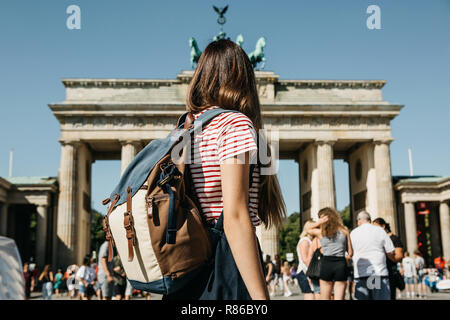 Un turista o uno studente con uno zaino a Berlino in Germania le visite alle attrazioni della città. Più avanti è la Porta di Brandeburgo e irriconoscibile persone sfocate. Foto Stock