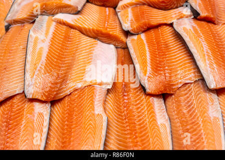 Piatti a base di frutti di mare freschi sul ghiaccio tritato al mercato del pesce. Materie filetto di salmone sul display del contatore in corrispondenza del magazzino. Pesce sfilettatura bacground. Foto Stock