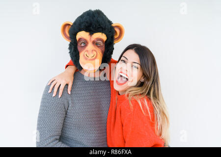 Divertente coppia giovane, ragazzo che indossa la maschera di scimmia, pazzo idiota e rapporto di amore Foto Stock