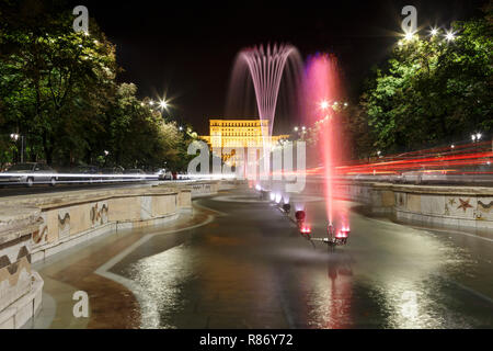 Edificio del Parlamento rumeno a Bucarest in una bella notte estiva, e fontane di fronte. Foto Stock