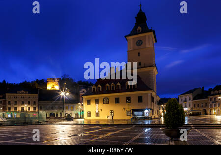 La piazza del Consiglio durante la pioggia in Brasov, Romania. Visualizzare con i famosi edifici di sera e luci di pubblico. Foto Stock