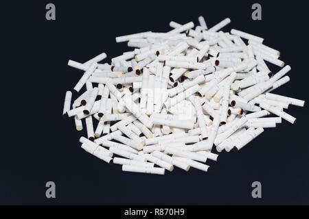 Nuovissimo le sigarette elettroniche, riscaldamento sistema di tabacco IQOS, fumatori, blu scuro isolati su sfondo nero. montagna di sigarette utilizzato, bastoni Foto Stock