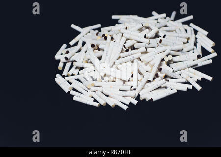 Nuovissimo le sigarette elettroniche, riscaldamento sistema di tabacco IQOS, fumatori, blu scuro isolati su sfondo nero. montagna di sigarette utilizzato, bastoni Foto Stock