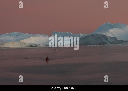 Ilulissat Tourist Nature Eisberge am Abend: Ausflugsboot streben in Kiellinie der AIDAcara entgegen. Foto Stock