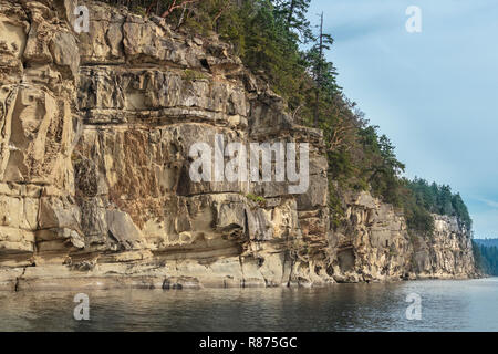 Lungo Valdes isola della costa, ripida, erose scogliere di arenaria formano intricate trame e modelli, con la foresta al di sopra di esse (British Columbia). Foto Stock