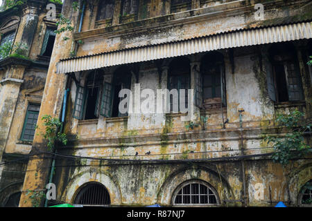 Vecchia facciata di un edificio vuoto, un esempio di British architettura coloniale di Yangon, Myanmar. Foto Stock