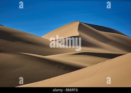 Le dune di sabbia del deserto , caldo sabbia asciutta sotto il cielo blu Foto Stock