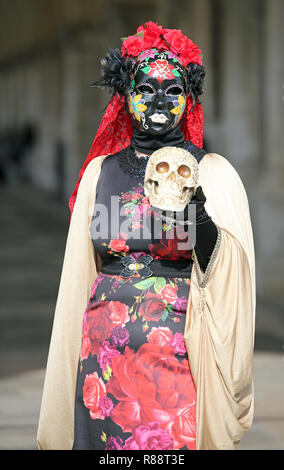 Venezia, VE, Italia - 5 Febbraio 2018: donna mascherata in un abito con motivo floreale durante il carnevale con un teschio in mano come Amleto Foto Stock