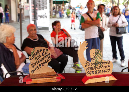 Scena di strada fino in prossimità della testa e della spalla ritagli con i nomi e i numeri di telefono delle persone sedute in background, Caracas, Venezuela, Sud America Foto Stock