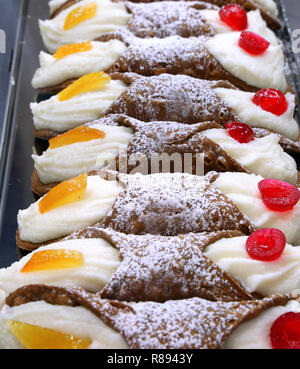 Tipica pasticceria siciliana denominato Cannoli farciti con ricotta e frutta candita per la vendita in un negozio di pasticceria Foto Stock