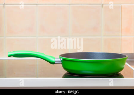 Green padella closeup sul vetro stufa in ceramica Foto Stock