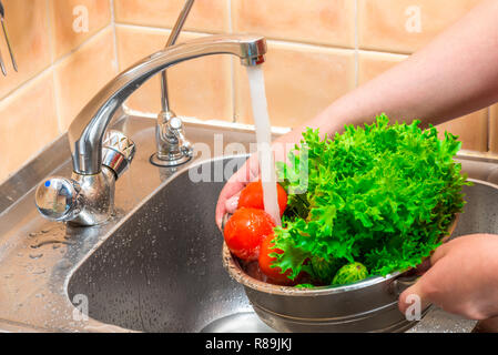 Preparare le verdure per la cottura, risciacquo in acqua corrente Foto Stock