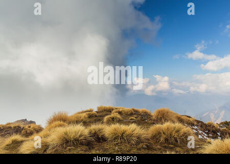 Grandi nuvole di cumulus oltre la metà della collina su una montagna di Annapurna Himal, Nepal, Himalaya, Asia Foto Stock