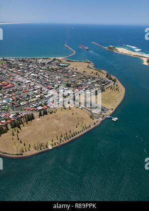 Un carbone nave lascia il porto di Newcastle vincolati ad una destinazione d'oltremare. Il lato del porto surburb di Stockton e Nobbys spiaggia su entrambi i lati di ha Foto Stock