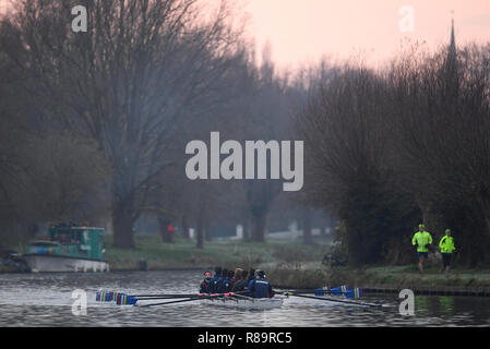 Persone jog sulle rive come i rematori di treno lungo il fiume Cam in Cambridge alla prima luce, come la prima nevicata della stagione sembra destinata a portare le interruzioni di viaggio nel periodo prenatalizio, secondo il Met Office. Foto Stock