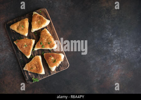 Fritte pasticci di carne, samsa, samosas, echpochmak - Le carni tradizionali torte ripiene o torte vegetariane su sfondo rustico, copia dello spazio. Foto Stock