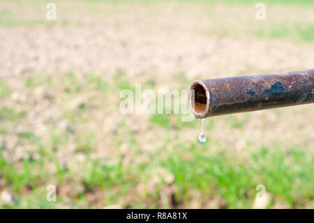 Goccia di acqua dal tubo rustico Foto Stock