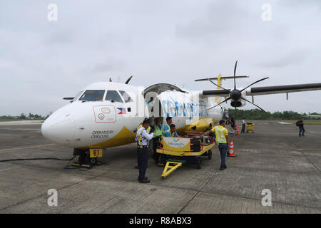 I gestori di bagagli scaricano i bagagli da un aereo Cebu Pacific ATR 72-500 della compagnia aerea filippina low-cost nell'aeroporto di Cauayan che serve l'area generale di Cauayan, una città nella provincia di Isabela nelle Filippine Foto Stock