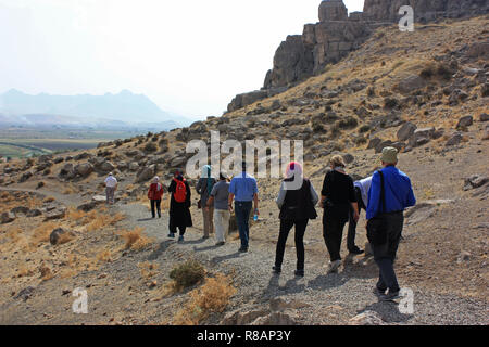 Bisotun, Iran. Xvi oct, 2018. Iran - Bisotun (Bisutun, Behistun, "luogo degli dèi"). Bisotun è un villaggio nella provincia di Kermanshah nell'Iran occidentale, gruppo turistico sulla strada per il complesso Sassanian Taq-e Bostan (Taq-i-Bustan) con le sue grotte e ben conservato di rilievo di roccia, Sito Patrimonio Mondiale dell'UNESCO. Il complesso, che era una volta in un Paradeisos (Re) giardino, si trova a 5 km a nord-est della città di Kermanshah in West Iran in mezzo ai monti Zagros e apparteneva alla storica regione di media . Prese su 16.10.2018. Credito: Rolf Zimmermann | in tutto il mondo di utilizzo/dpa/Alamy Live News Foto Stock