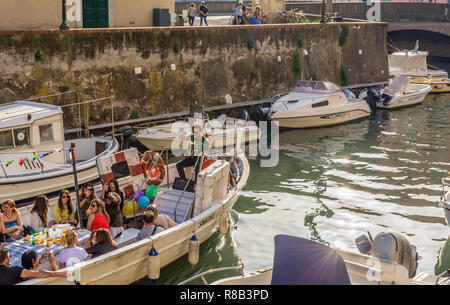 I turisti sulla barca in Livorno Canal, Venezia distretto. Il quartiere di Venezia è il più affascinante e pittoresca parte della città di Livorno in Tus Foto Stock