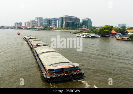 Rimorchiatore che traina una chiatta sul fiume Chao Phraya, Bangkok, Thailandia Foto Stock