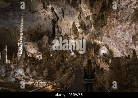 Una ragazza circondata da stalattiti e stalagmiti, esplorando le caverne di Carlsbad Caverns nel sud del Nuovo Messico, STATI UNITI D'AMERICA Foto Stock