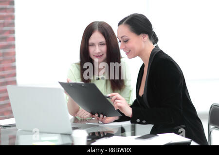 Close up. business donna rendendo note seduto sulla sua scrivania Foto Stock