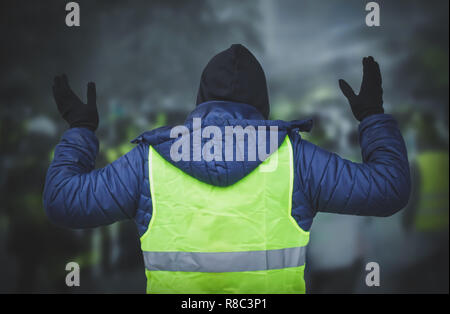 Uomo in un giubbotto giallo protestando Foto Stock