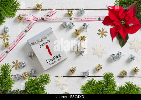 Strappare il calendario circondata da decorazioni natalizie e con il 1° gennaio 2019 (in tedesco) sulla parte superiore Foto Stock