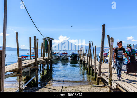 Panajachel, lago Atitlan, Guatemala - Novembre 12, 2018: locali imbarcati e sbarcati dai battelli diretti verso i villaggi con San Pedro vulcano dietro. Foto Stock